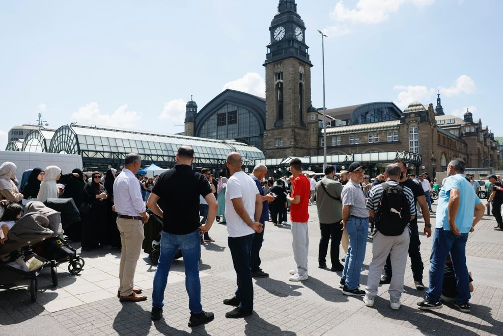 Demonstranten stehen auf dem Hachmannplatz vor dem Hauptbahnhof.