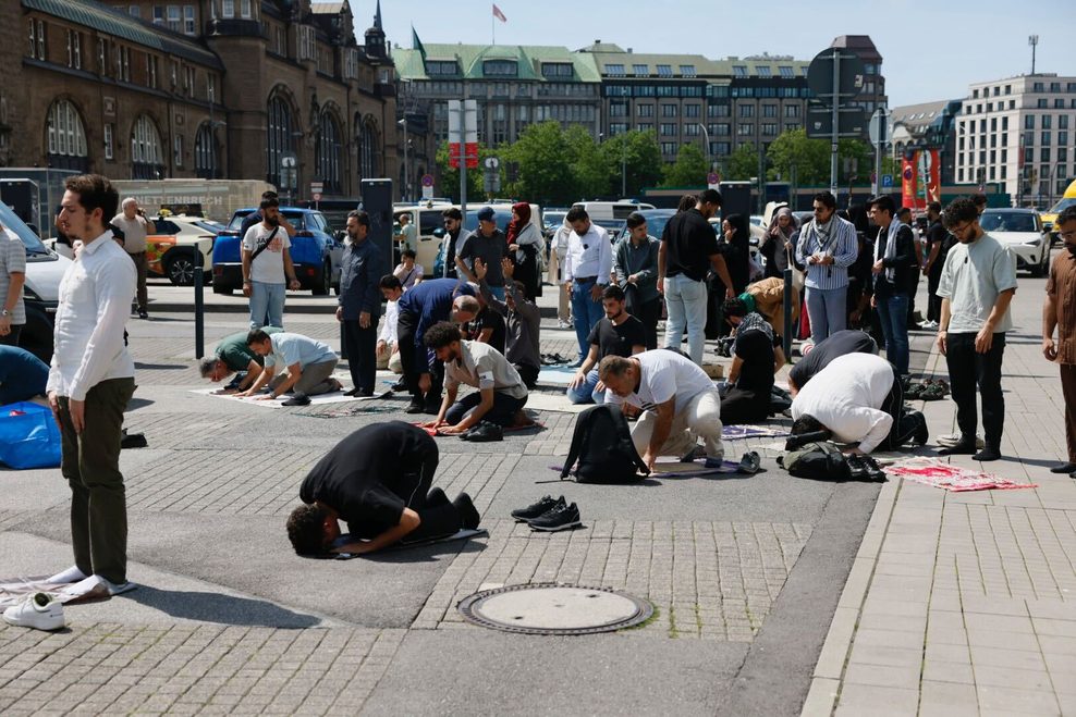 Eine kleine Gruppe männlicher Demonstranten betet am Rand des Hachmannplatzes.