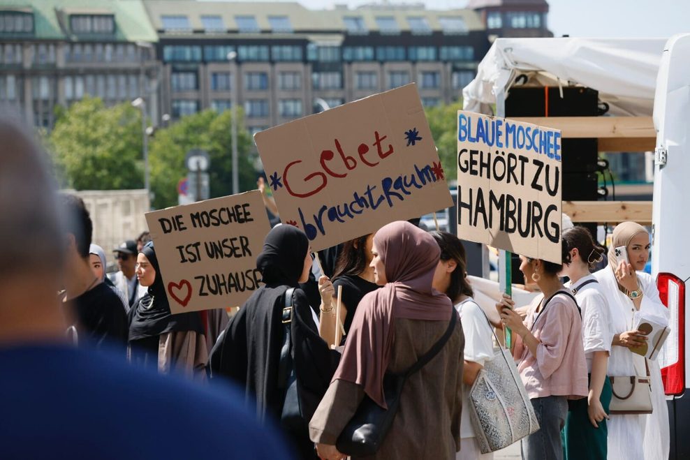 „Gebet braucht Raum“ steht auf einem Pappschild.