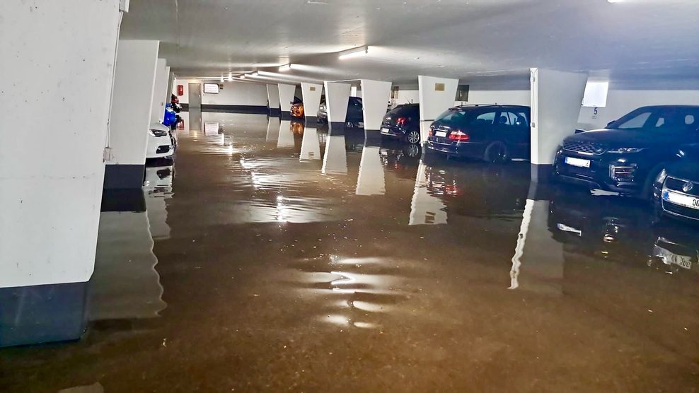 Autos stehen in einer überschwemmten Tiefgarage.