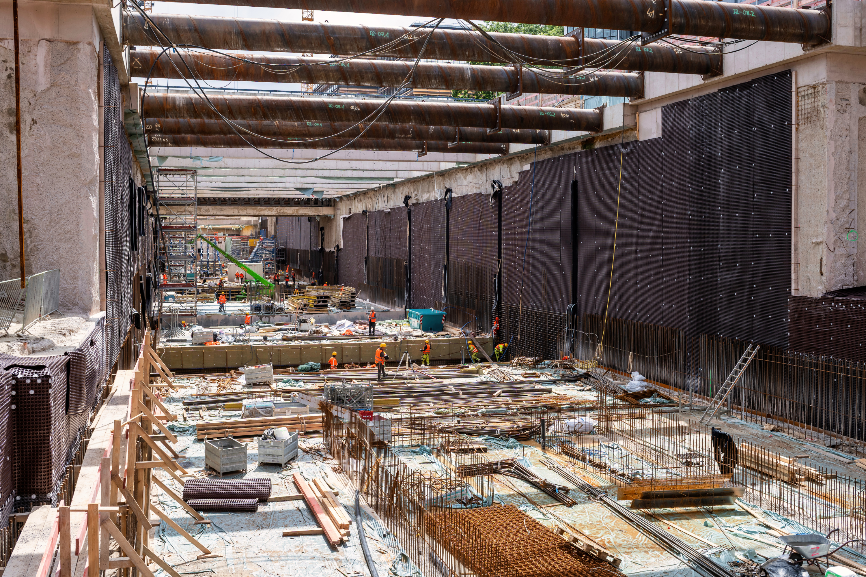 In der 18 Meter tiefen Baugrube werkeln die Arbeiter bereits am Rohbau der neuen U5-Haltestelle.