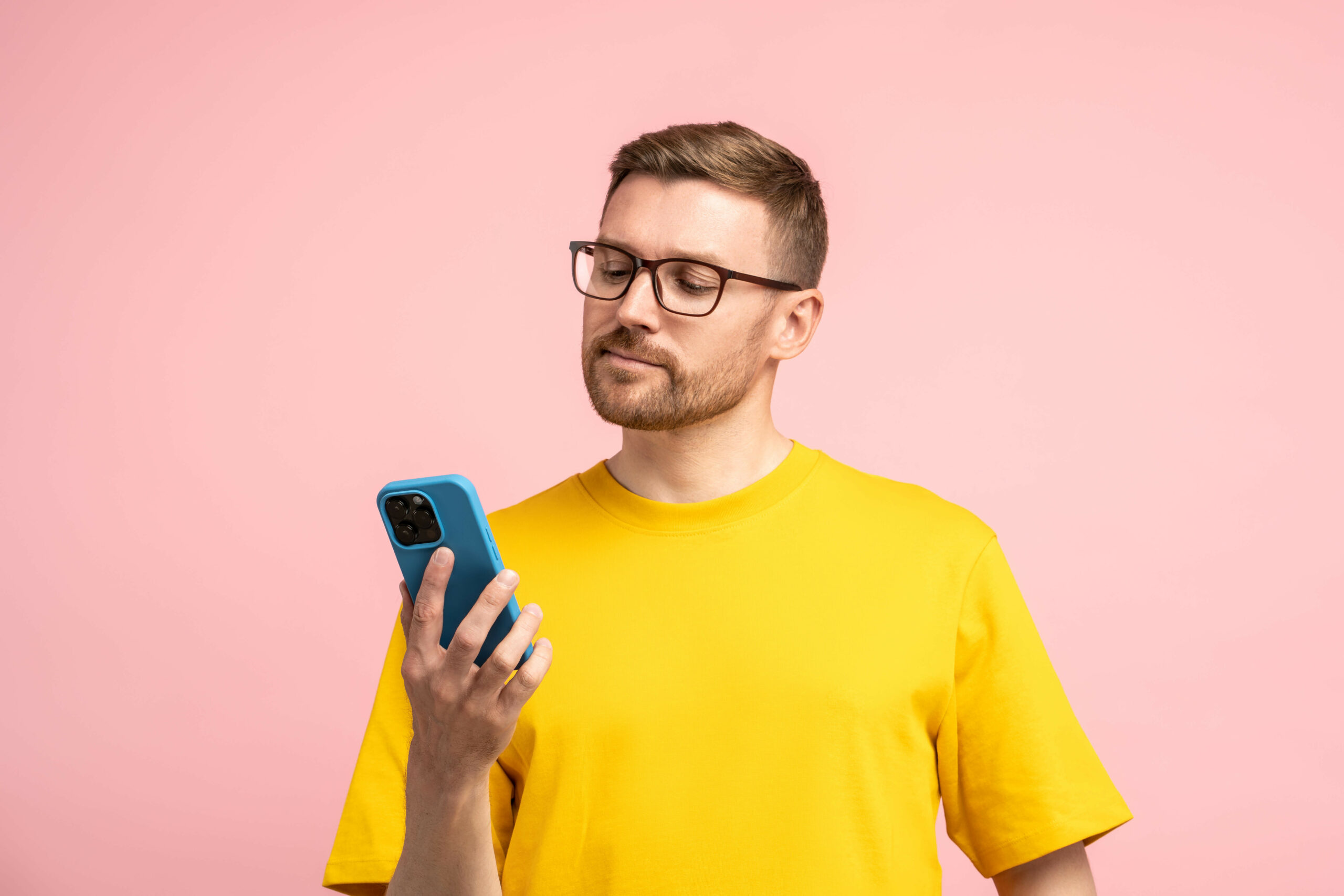 Ein junger Mann sieht auf sein Smartphone