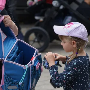 Mädchen bekommt Schulranzen.