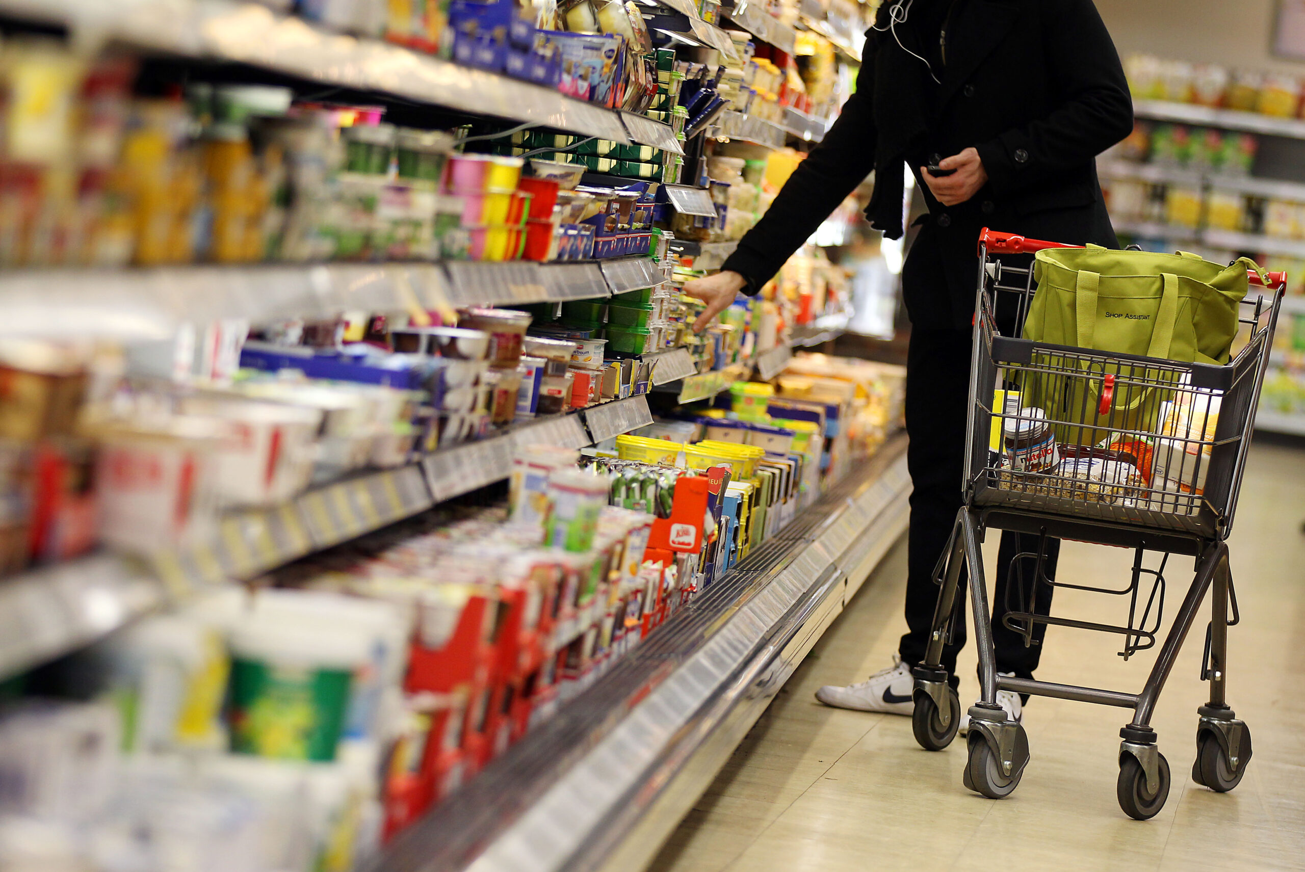 Ein Kunde bedient sich im Supermarkt-Regal.