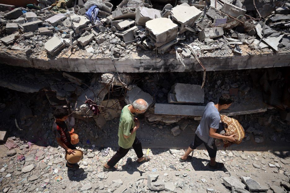 Menschen in Gaza laufen an Trümmern vorbei.