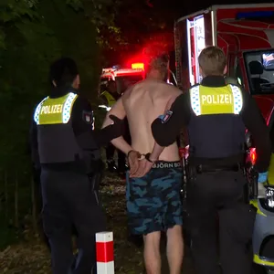 Der Verdächtige wird von Polizisten aus dem Wohnheim abgeführt