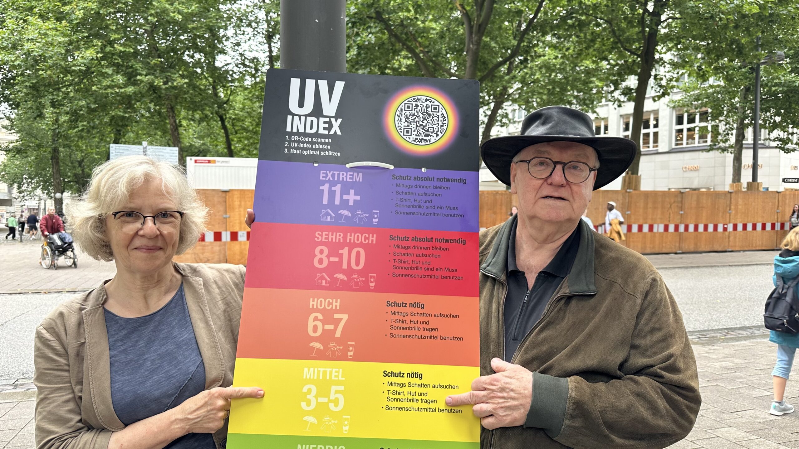 Ein Mann und eine Frau halten ein buntes Plakat