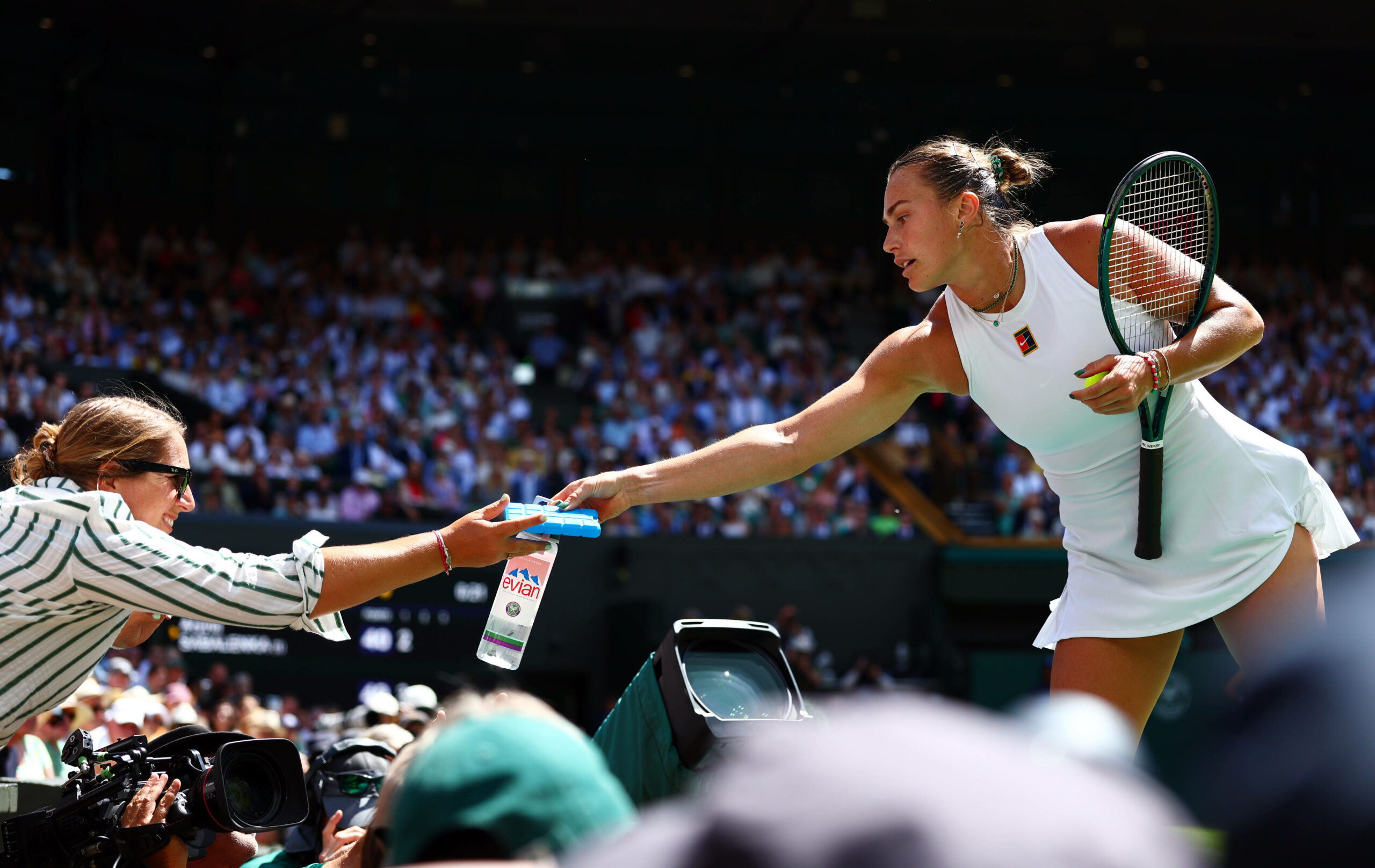 Sabalenka reicht einer Zuschauerin eine Flasche Wasser