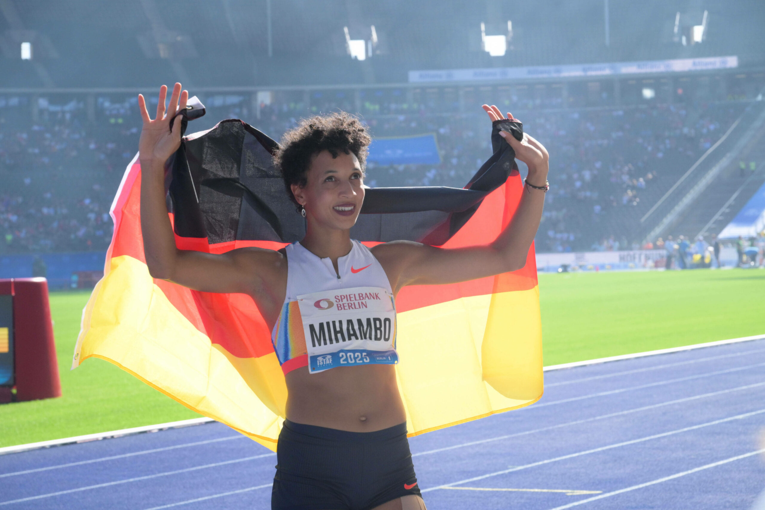 Malaika Mihambo jubelt beim ISTAF in Berlin mit deutscher Fahne.