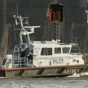 Das Lotsenboot Lotse 4 fährt neben einem Containerschiff entlang. Altona Hamburg *** Pilot boat pilot 4 sails next to a