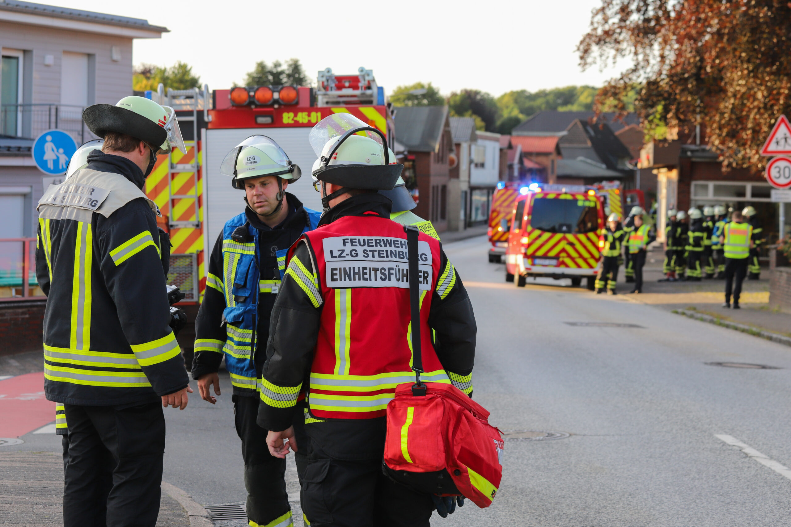 Einsatzkräfte de Feuerwehr stehen auf der Straße.