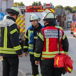 Einsatzkräfte de Feuerwehr stehen auf der Straße.