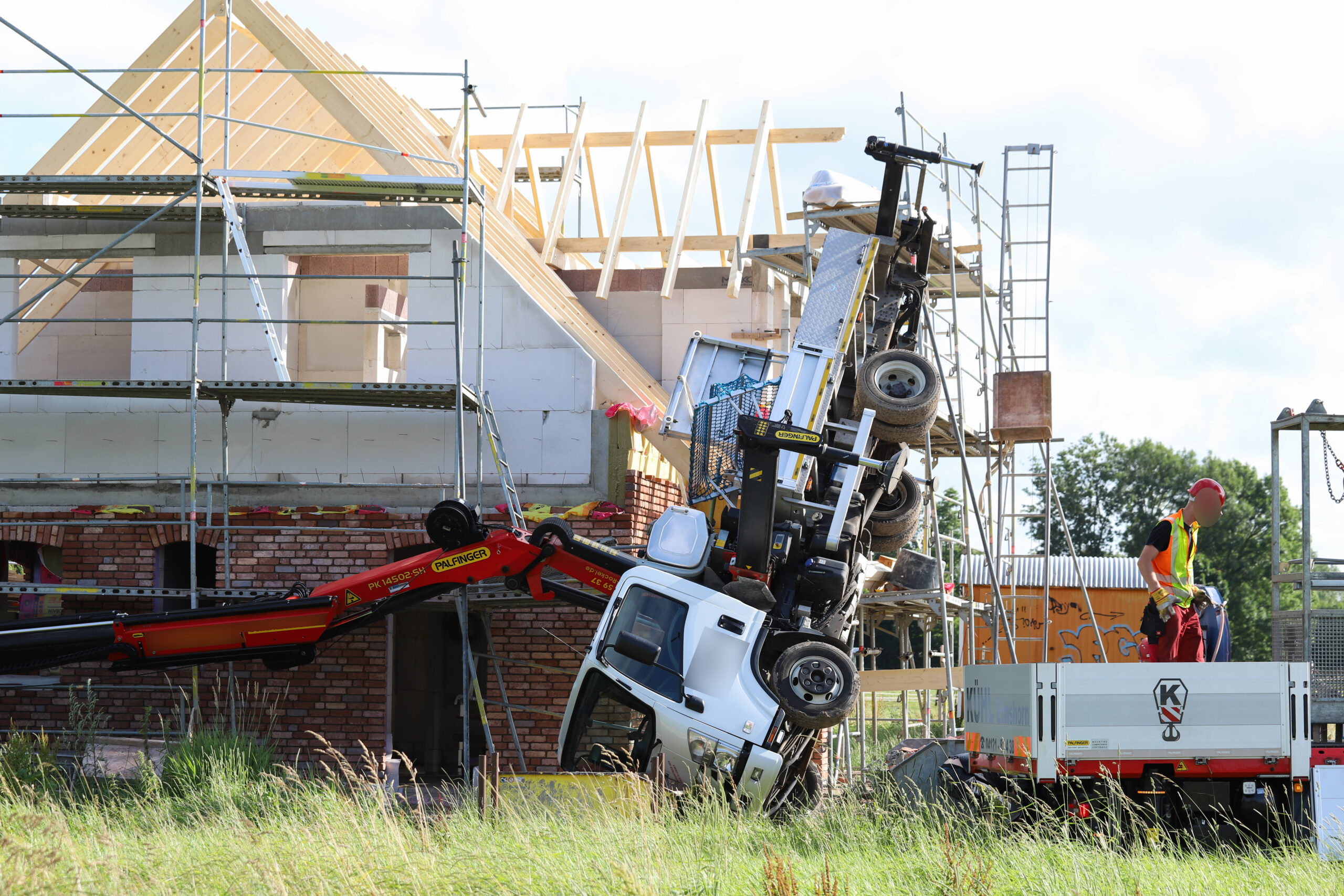 Ein Lkw-Ladekran ist an einem Neubau umgekippt.