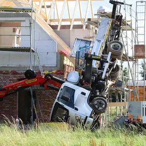 Ein Lkw-Ladekran ist an einem Neubau umgekippt.