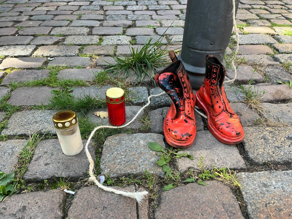 Rote Schuhe und Grablichter