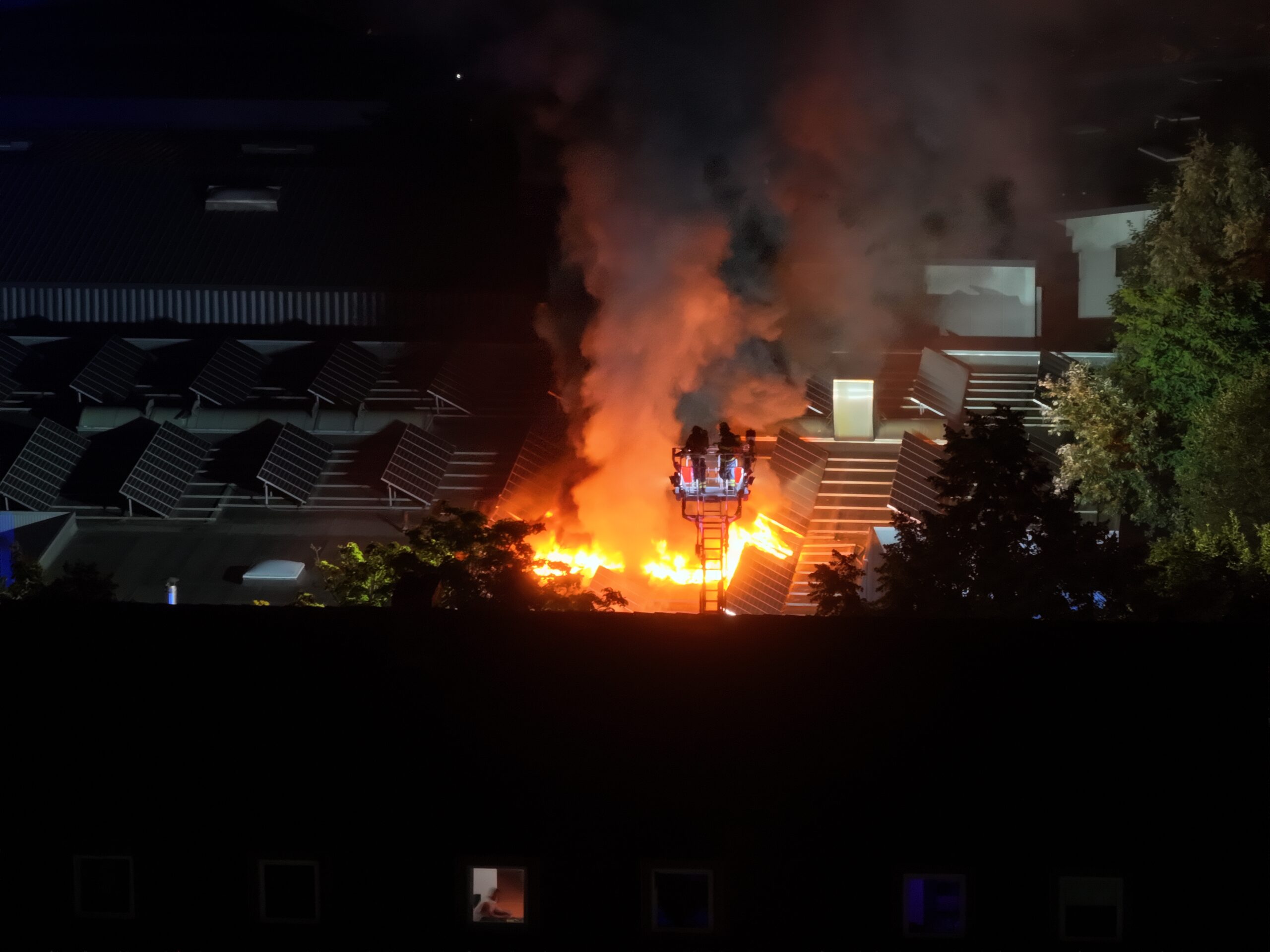 Eine Drohnen-Aufnahme von dem brennenden Dach der Halle.
