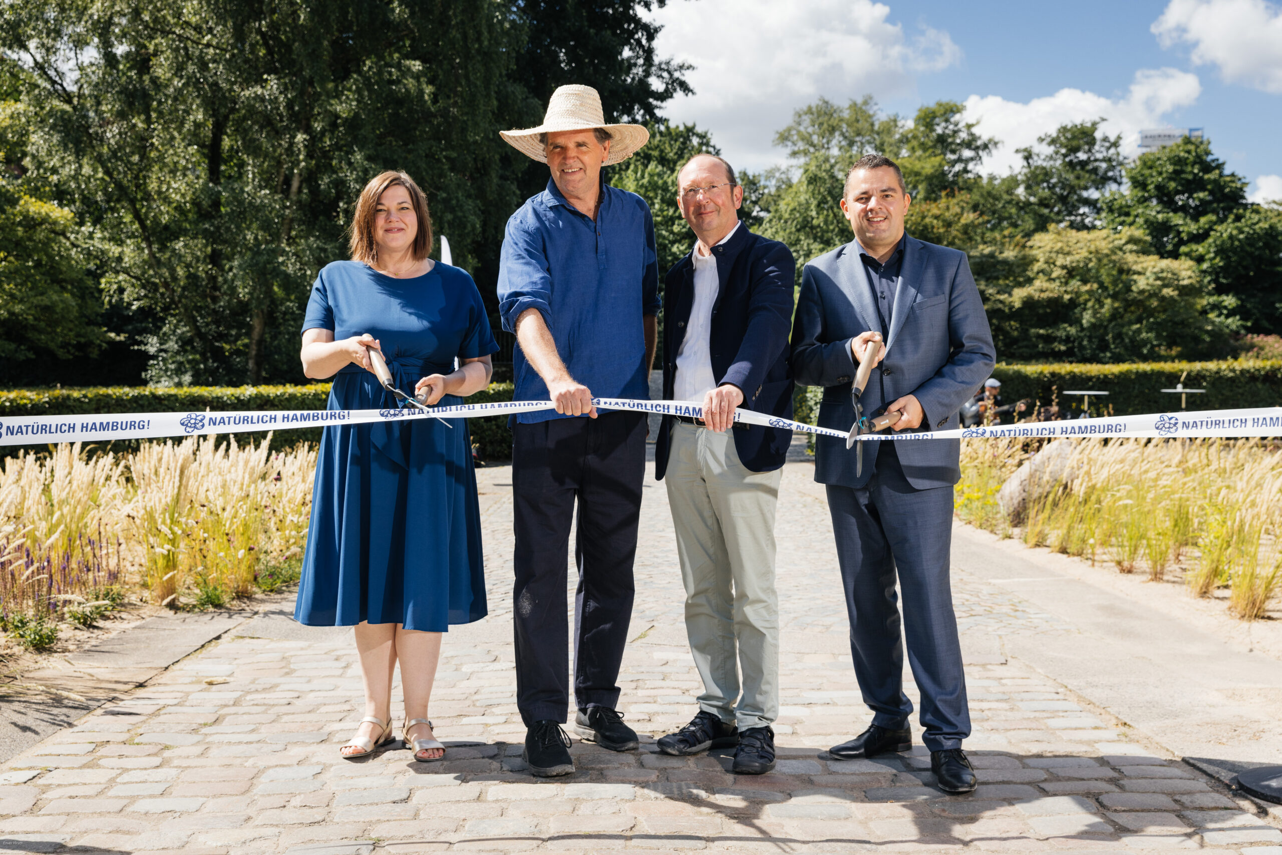 Umweltsenatorin Katharina Fegebank (Grüne), Gartenarchitekt Tom Stuart-Smith, Matthias Herbert (Bundesamt für Naturschutz) und Bezirksamtsleiter Ralf Neubauer (SPD) durchschneiden ein Eröffnungsband.