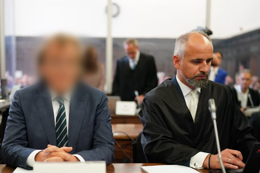 Verteidiger Marco Voss (r) sitzt neben seinem Mandanten C.