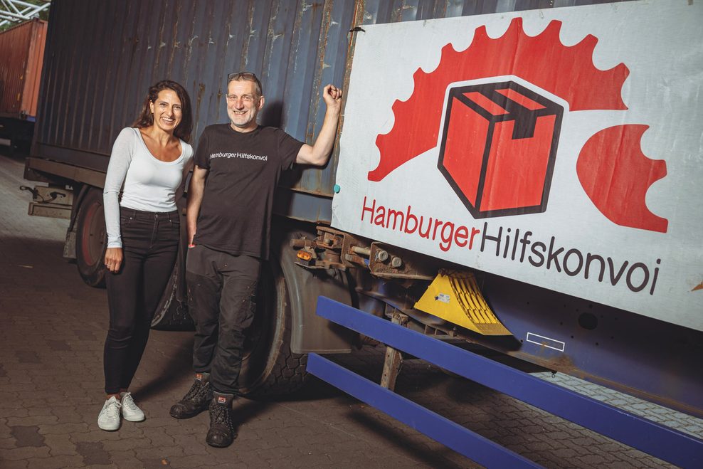 Cigdem Göncü von der Haspa-Filiale Eidelstedt mit Christian Großeholz vor einem Laster mit Hilfsgütern.