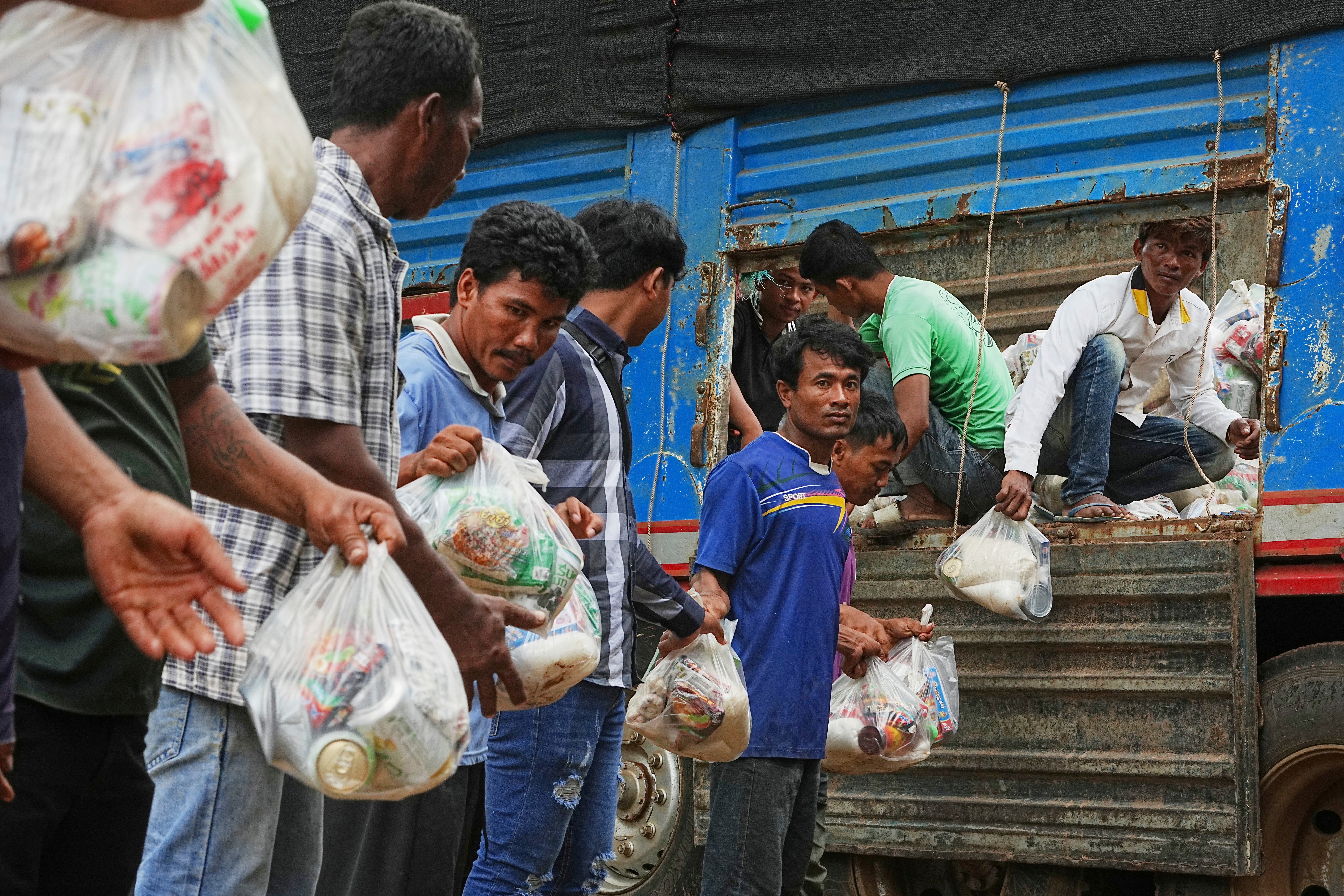 Einheimische Dorfbewohner helfen beim Abladen von Hilfsgütern, die von einer Wohltätigkeitsorganisation für Flüchtlinge gespendet wurden, die in Wat Phnom Kamboar in der Provinz Oddar Meanchey in Kambodscha Zuflucht suchen.
