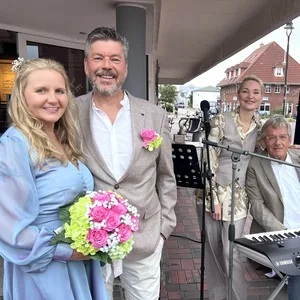 Manuela und Norbert Voß (l.) haben am Freitag im Standesamt im Rathaus geheiratet. Das Ständchen, was sie sich vom Musikduo Wolfgang Grund und Justyna Hejman (r.) gewünscht hatten, musste vor das Café „Stulle & Meer“ verlegt werden. Das Standesamt konnte keine Steckdose zur Verfügung stellen.