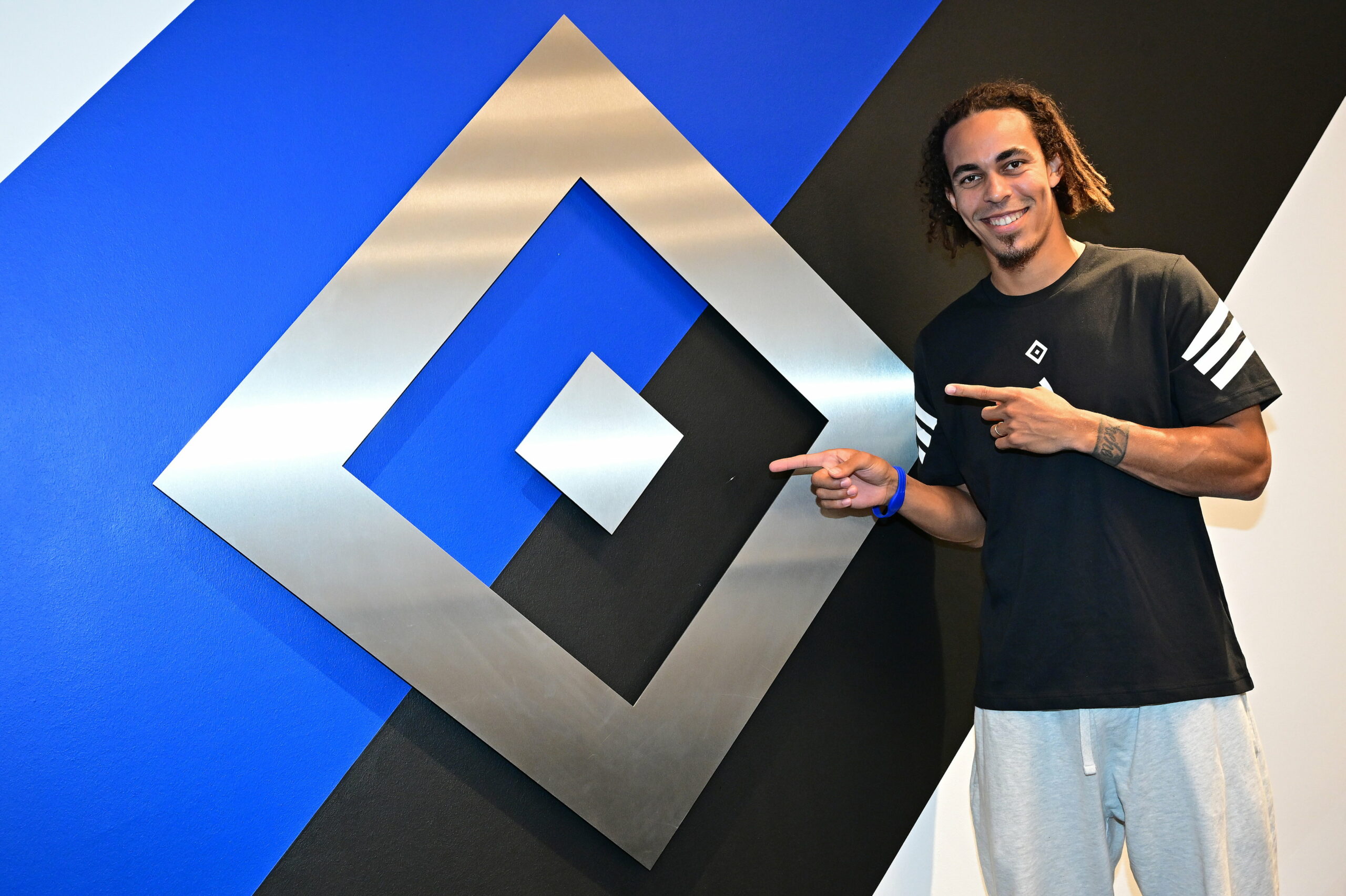 Yussuf Poulsen posiert vor der HSV-Raute
