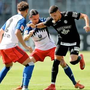 Die HSV-Profis William Mikelbrencis und Rayan Philippe im Duell mit dem Grazer Emir Karic