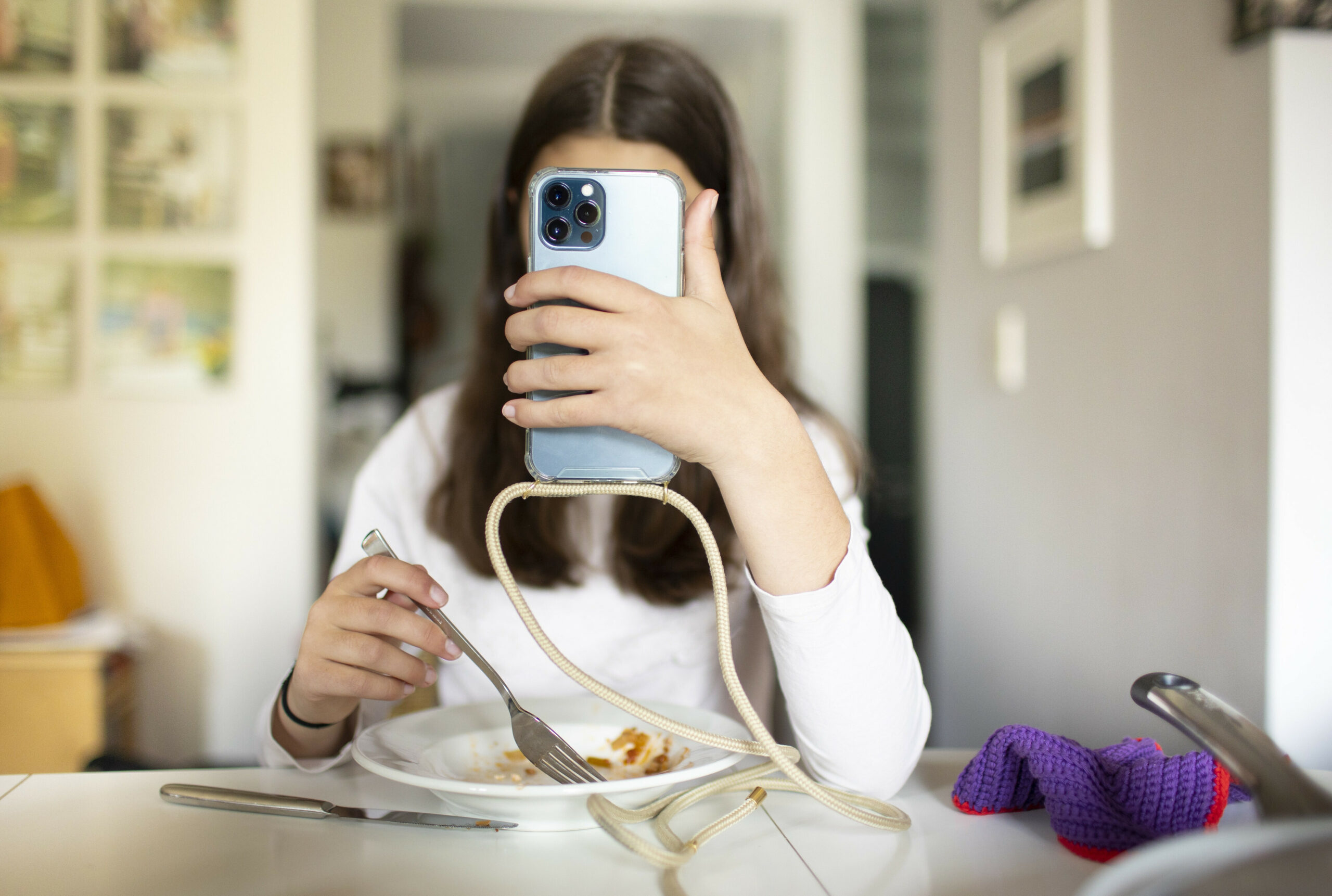 Junge Frau mit Teller und Smartphone