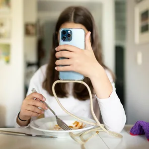 Junge Frau mit Teller und Smartphone
