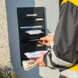 Postbote wirft Post in Briefkasten