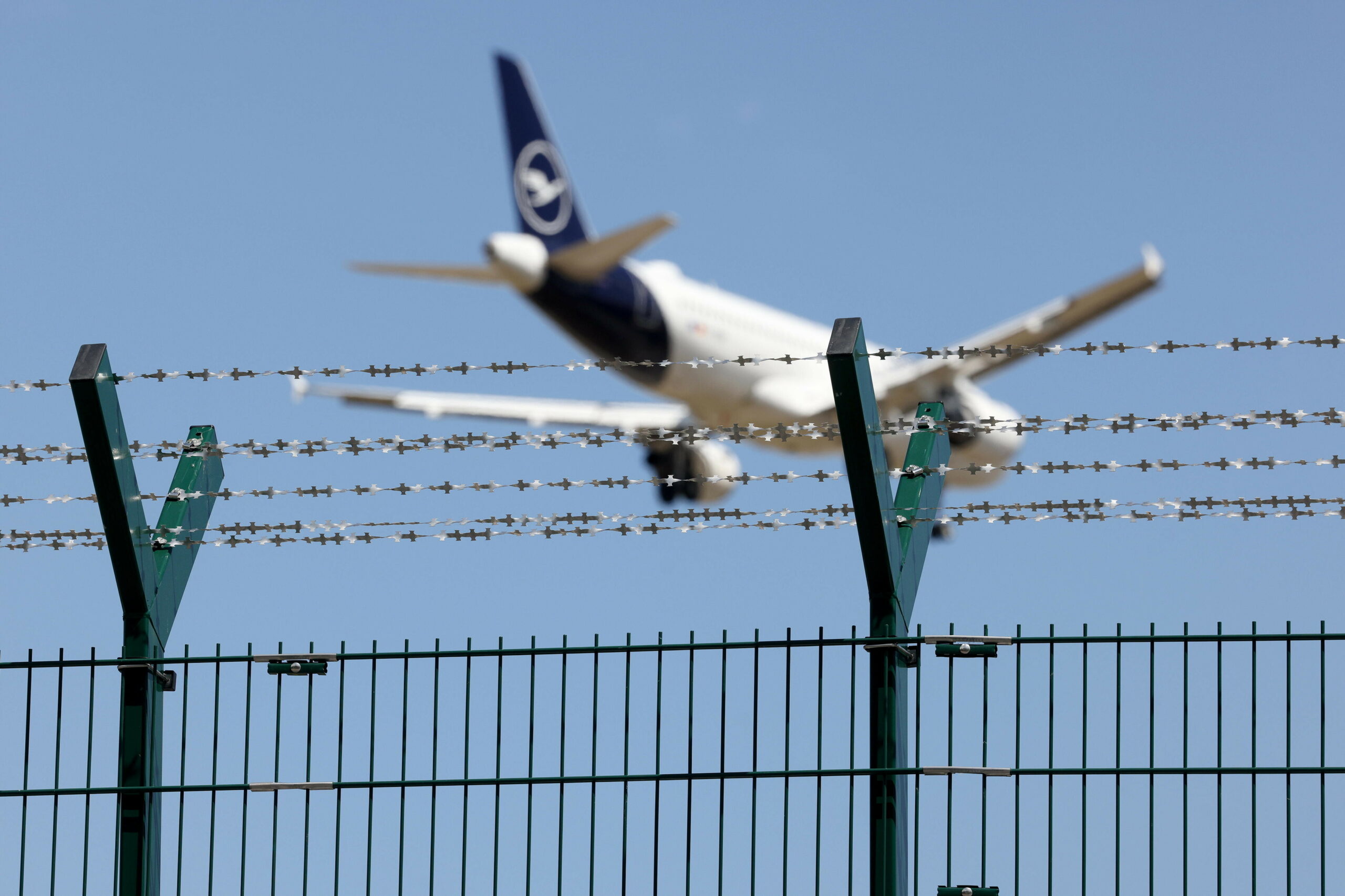 Ein Flugzeug hinter einem Zaun.