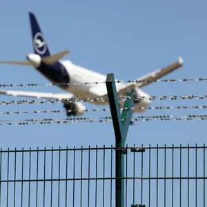 Ein Flugzeug hinter einem Zaun.