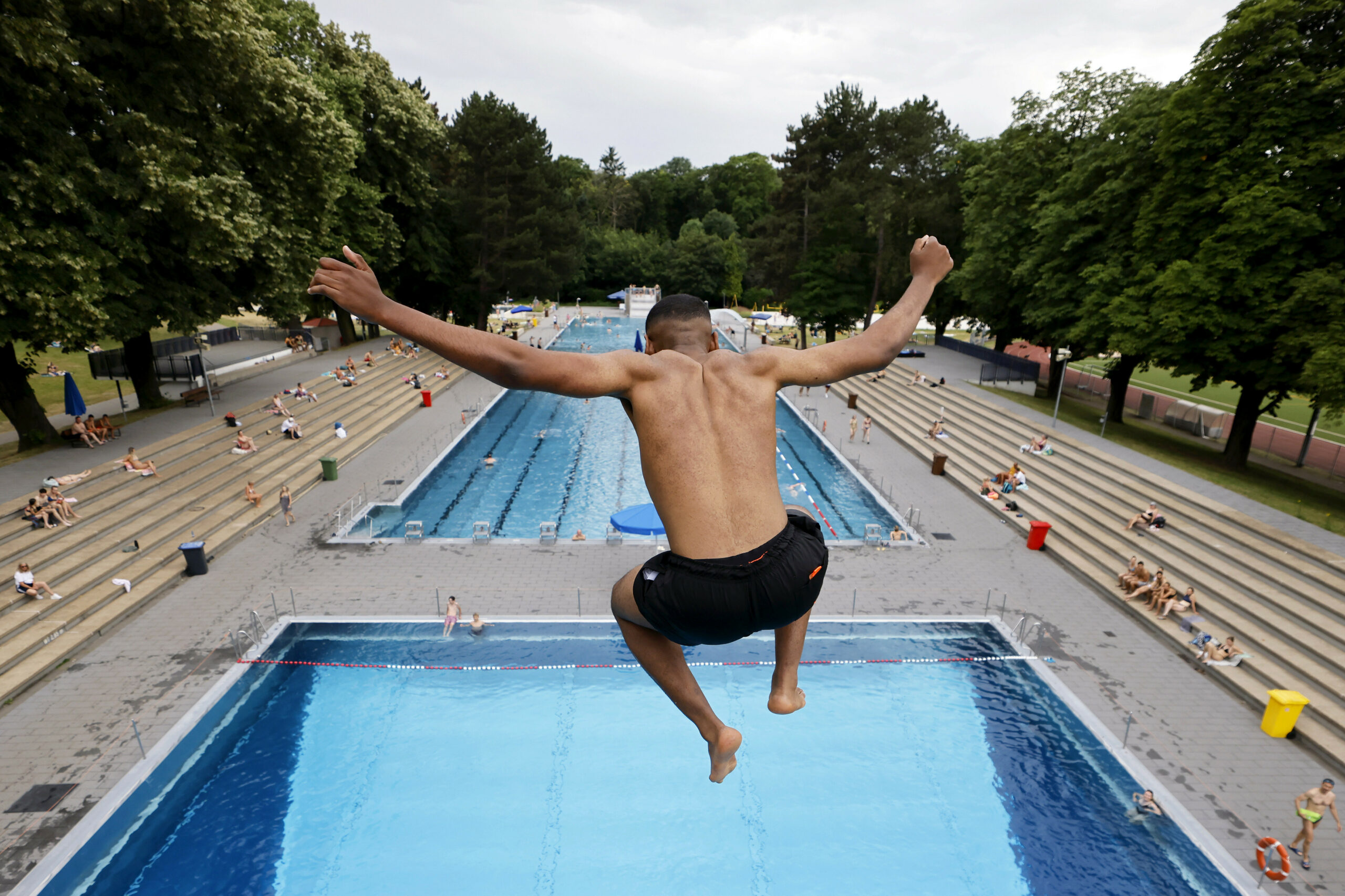 Ein Junge springt vom Sprungturm ins Wasser