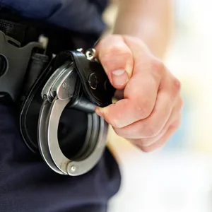 Ein Polizist hält Handschellen.