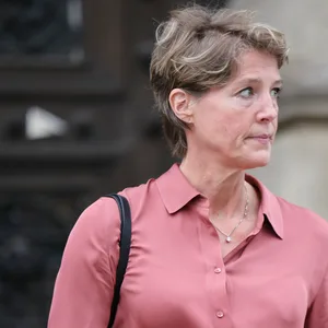 Frau in rosa Bluse vor Gerichtsgebäude