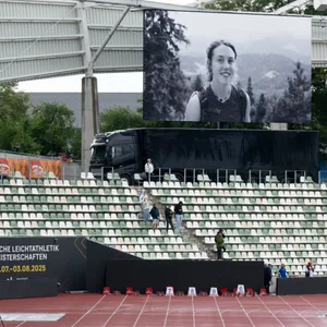 Auf einer Stadionleinwand ist ein Schwarz-Weiß-Foto von Laura Dahlmeier zu sehen