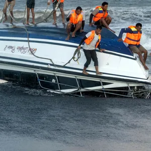 Menschen in Rettungswesten auf einem gekenterten Boot