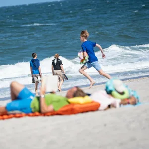 Kinder spielen an einem Strand an der Nordsee.