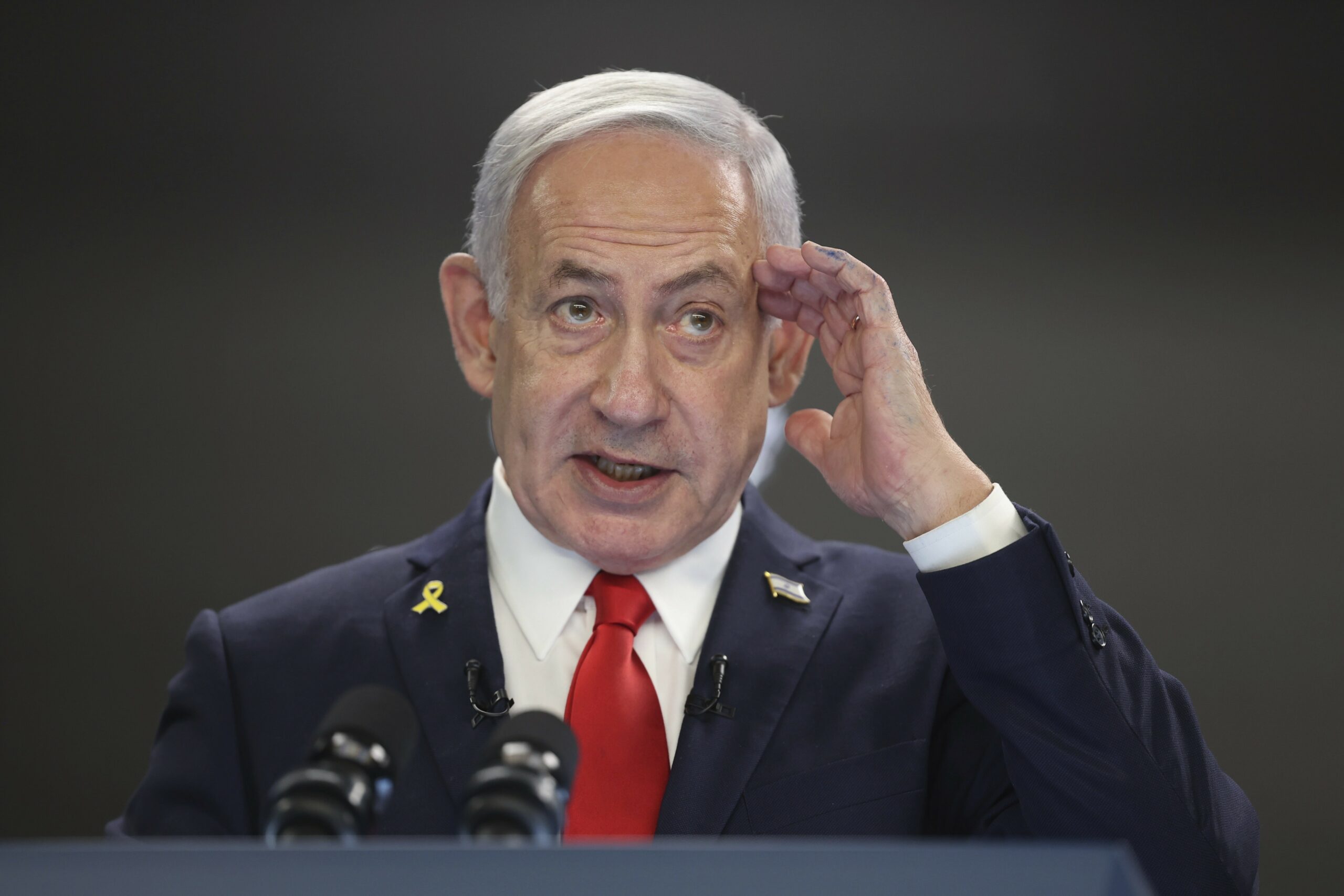 Der israelische Ministerpräsident Benjamin Netanjahu steht vor einem Mikrofon.