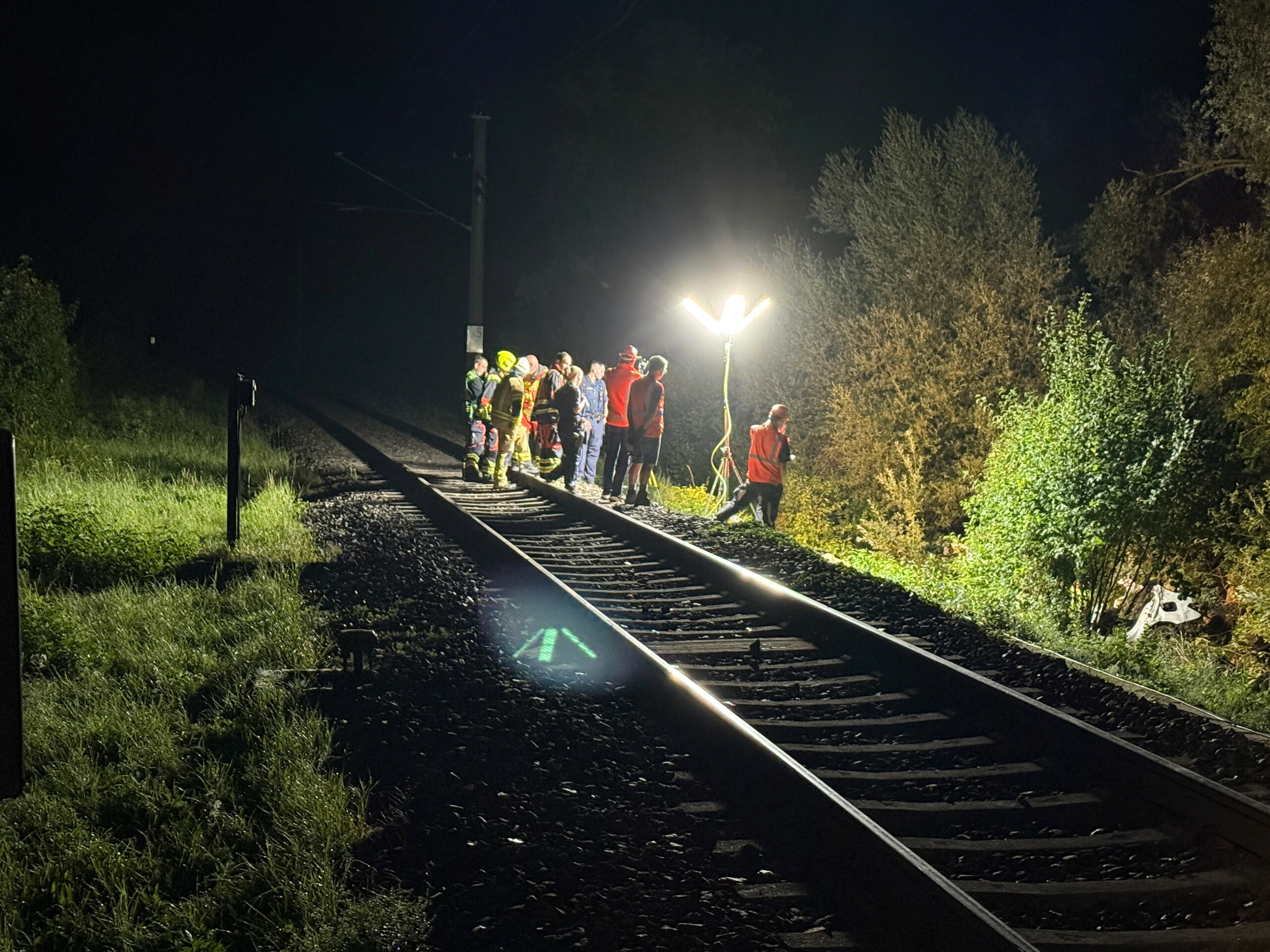 Rettungskräfte stehen an der Unglücksstelle am Bahnübergang bei Manching.