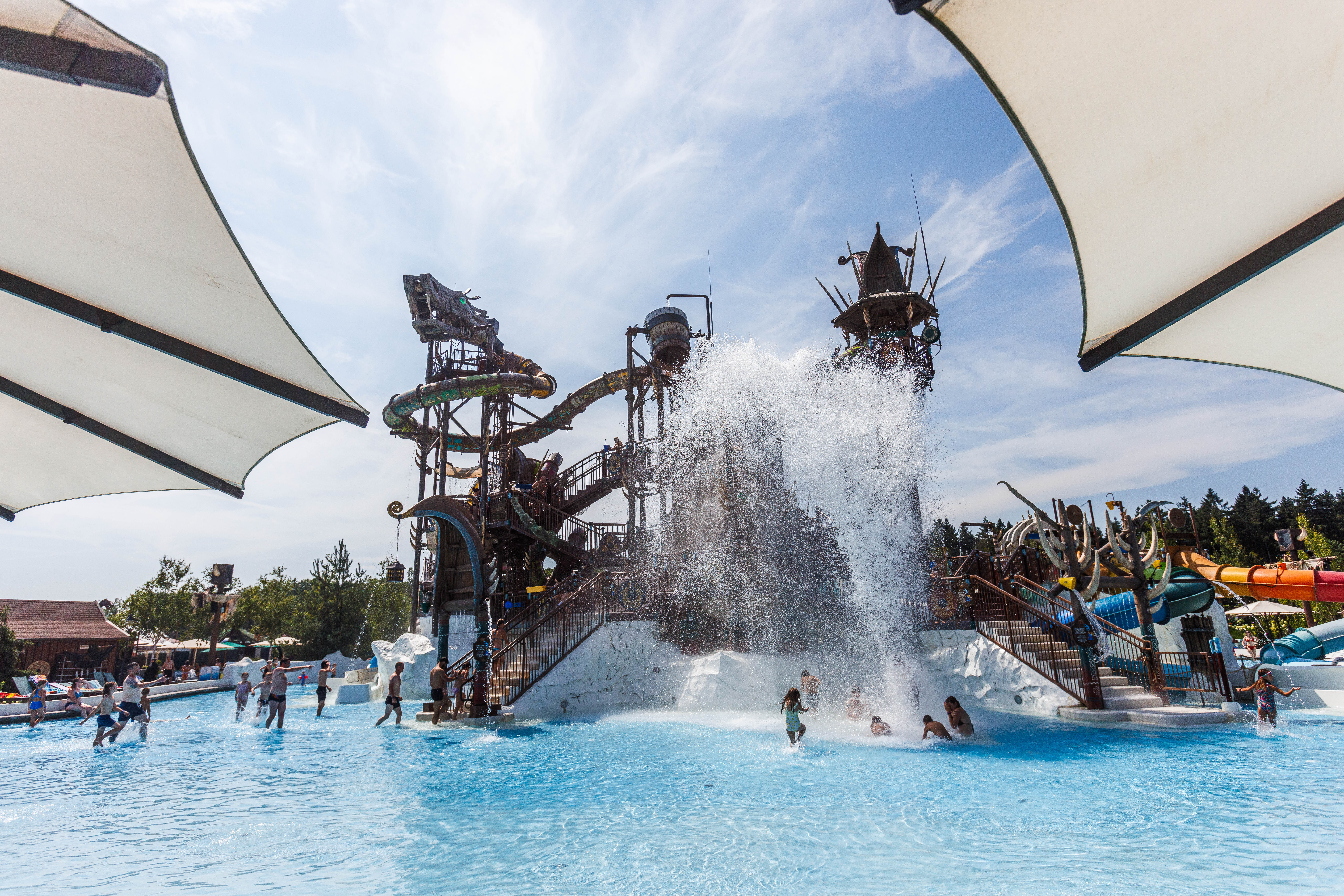 Wasser fällt aus einer Attraktion auf Menschen, die im Wasserpark Rulantica baden.