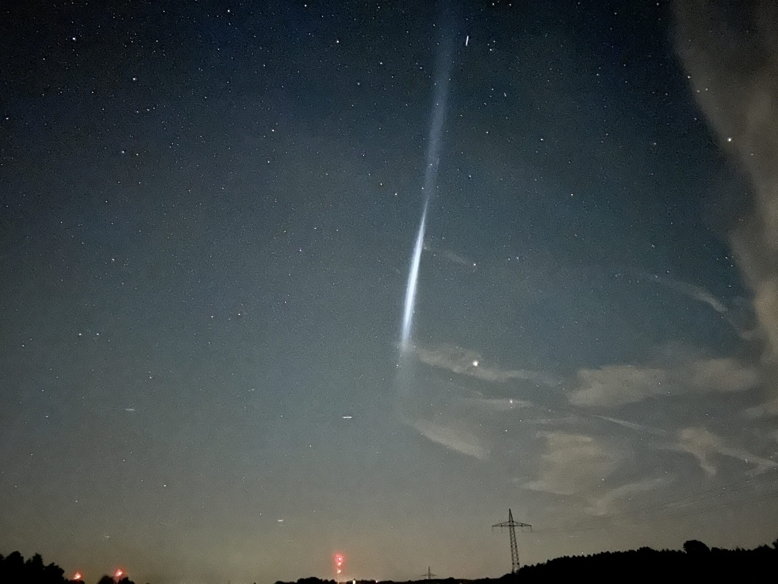 Ein Lichtschweif ist in der Nacht am Himmel zu sehen.