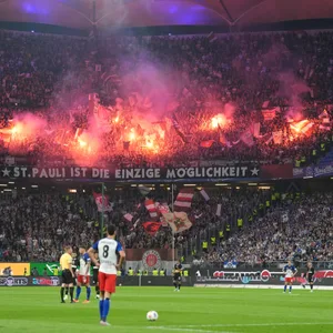 Fans des FC St. Pauli feiern im Auswärtsblock des Volksparkstadions.