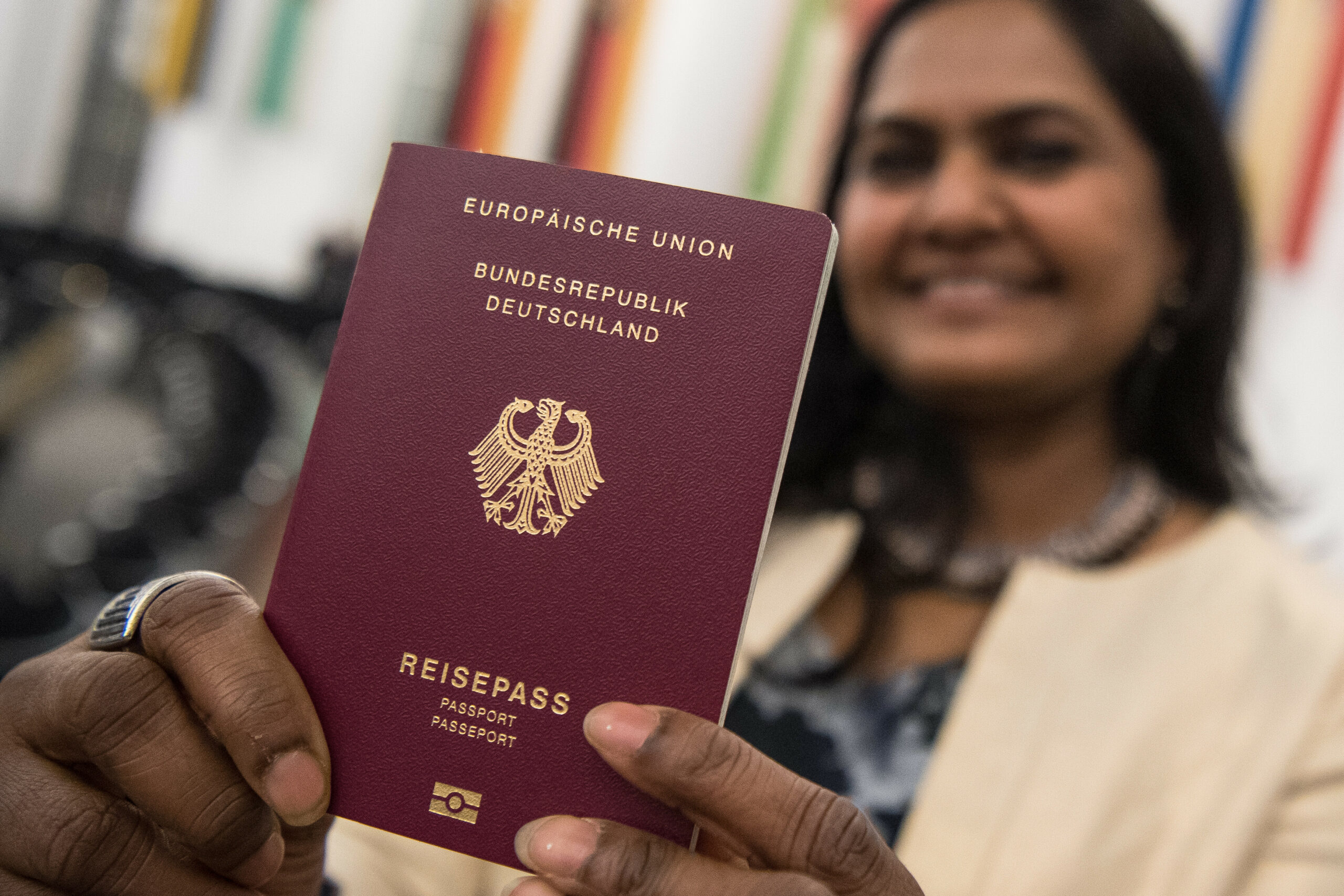 Eine Frau hält ihren deutschen Pass in die Kamera (Symbolfoto).