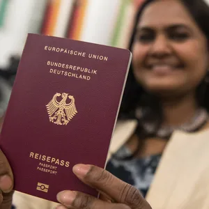 Eine Frau hält ihren deutschen Pass in die Kamera (Symbolfoto).