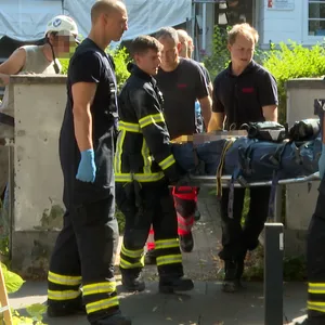 Rettungskräfte bringen den schwer verletzten Arbeiter zum Rettungswagen.