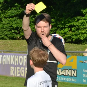 MOPO-Redakteur Robin Meyer zeigt einem Kind die Gelbe Karte