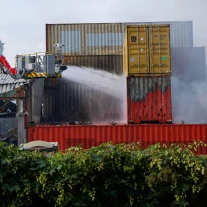 Feuerwehrkräfte löschen am Mittwochmorgen Container auf dem Gelände einer Spedition auf der Veddel in Hamburg.