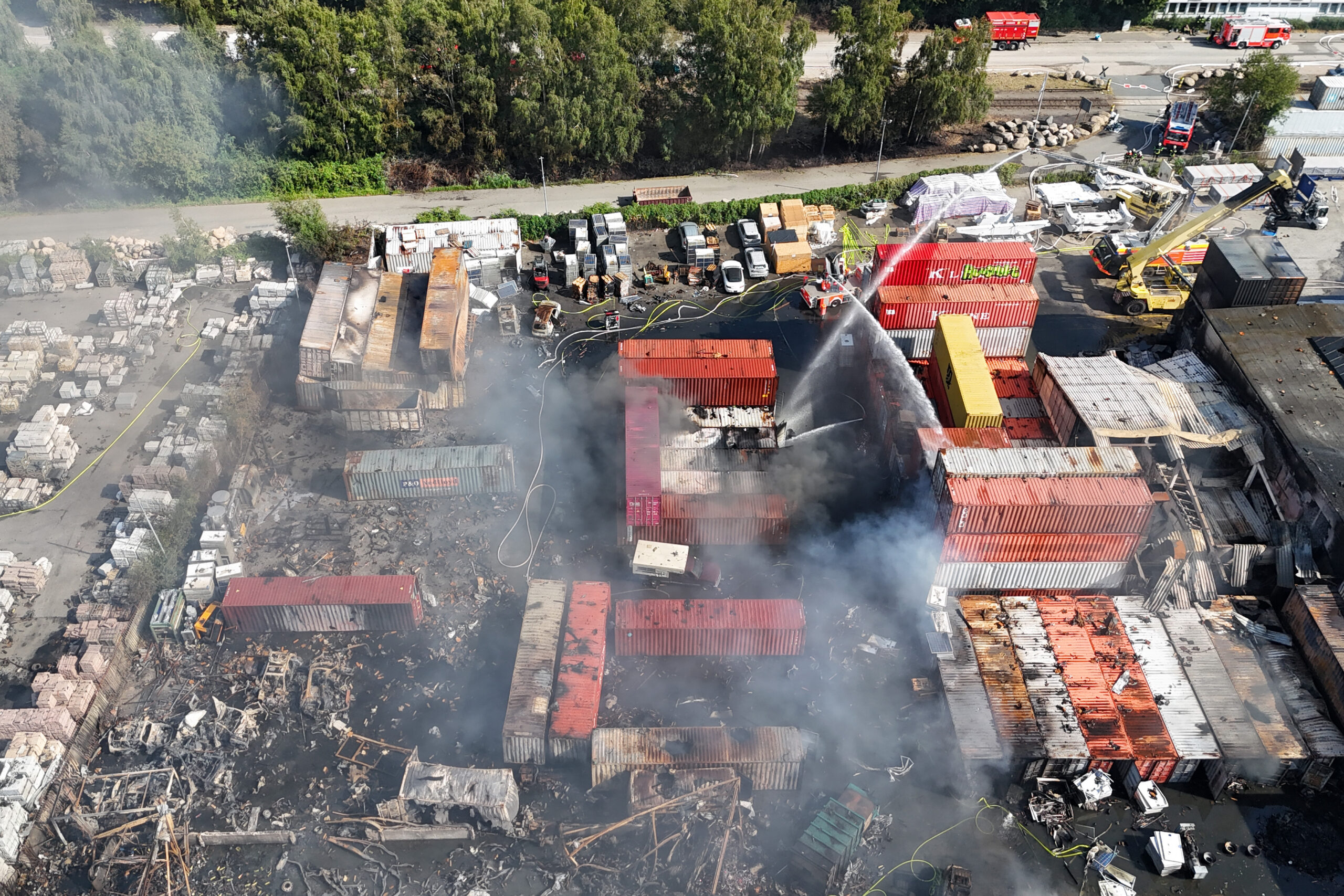 Einsatzkräfte der Feuerwehr löschen den Großbrand auf der Veddel in Hamburg.