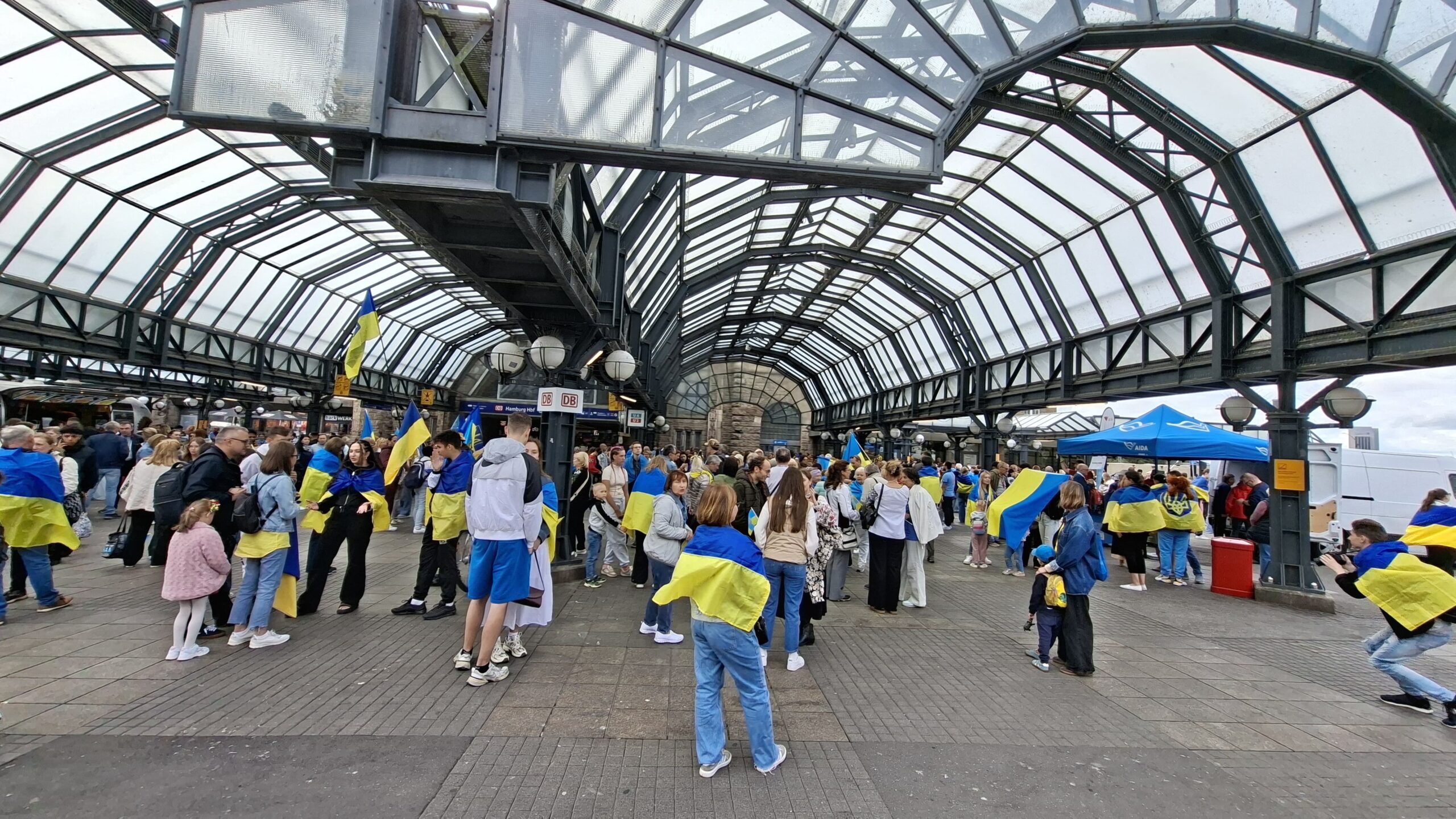 Menschen mit blau-gelben Fahnen am Hauptbahnhof